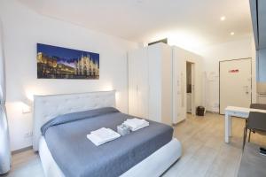 - une chambre avec un lit et 2 serviettes dans l'établissement MagnoliaApartments - 16 Meravigli Duomo, à Milan