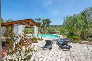 a patio with chairs and a swimming pool at Georgina House in Velianitátika