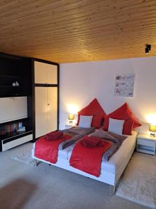 een slaapkamer met een groot bed met rode kussens bij Ferien- und Business Wohnung in Mönsheim