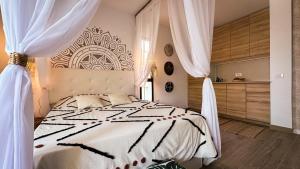 a bedroom with a large bed with white curtains at The Green Hut - Costa Adeje in Adeje