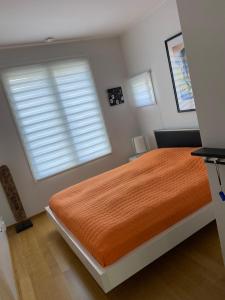 1 dormitorio con 1 cama grande de color naranja y ventana en Studio Nordcenter, en Raasepori