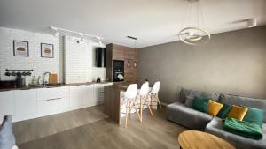 kuchnia i salon z kanapą i krzesłami w obiekcie Apartament Złocień w Krakowie