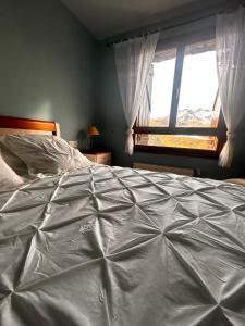 a large bed in a bedroom with a window at Formigal Valle del tena Rural Home in Formigal