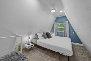ein Schlafzimmer mit einem weißen Bett und einem Fenster in der Unterkunft Lakefront Escape-Hot Tub-FirePit-Rural Retreat in Melrose