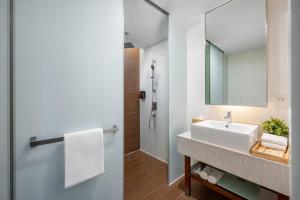 a bathroom with a sink and a mirror at Oasia Suites Kuala Lumpur by Far East Hospitality in Kuala Lumpur