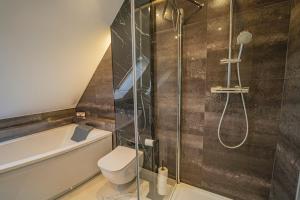 La salle de bains est pourvue d'une douche, de toilettes et d'une baignoire. dans l'établissement Apartament Boczna 3/3, à Karpacz