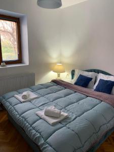 ein großes blaues Bett in einem Schlafzimmer mit Handtüchern darauf in der Unterkunft Garden Oasis Apartment in Veles