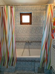 y baño con bañera y cortinas de ducha coloridas. en Garden Oasis Apartment en Veles