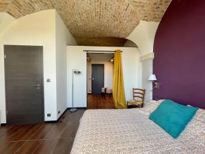 a bedroom with a large bed with a purple wall at Ancien domaine de Chartreux avec jacuzzi in Tullins