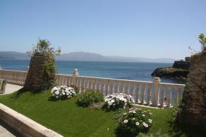 a garden with flowers on a fence near the ocean at Casa de Ángeles in Fisterra