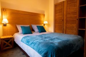 1 dormitorio con 1 cama grande con almohadas azules en Résidence Cami Réal **** en Saint-Lary-Soulan