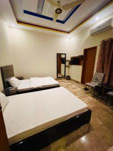 a bedroom with two beds and a ceiling at Hotel Bed & Rest Airport in Karachi