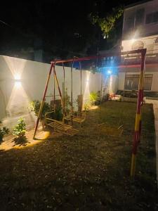 a swing set in a yard at night at Hotel Bed & Rest Airport in Karachi