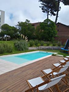 ビージャ・ヘセルにあるMAReSSの木製デッキの横にラウンジチェア付きのスイミングプール