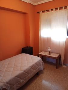 um quarto com uma cama, uma janela e uma mesa em Apartamento tradicional em Canet d'En Berenguer