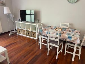 een eetkamer met een tafel en een televisie bij Viviendas Turísticas Los Cubos de Llanes 3 in Llanes