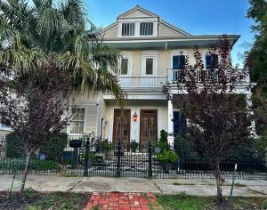 una casa bianca con una recinzione di fronte di The Dragonfly Guest House a New Orleans