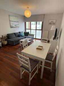 een woonkamer met een tafel en een bank bij Viviendas Turísticas Los Cubos de Llanes 3 in Llanes +4 foto's