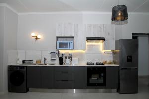 a kitchen with a sink and a stove and a refrigerator at Sublime - By LaSerene - Carlswald in Midrand