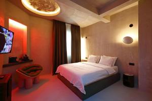 Habitación de hotel con cama y TV en Paradox, en Tesalónica