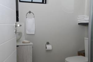 a white bathroom with a toilet and a sink at Sublime - By LaSerene - Carlswald in Midrand +18 photos