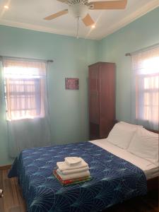1 dormitorio con 1 cama con toallas en The Lily Pad en Caye Caulker
