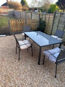 a table with two chairs and a table with a glass top at Bentley Bridge Wolverhampton 3 Bedrooms Entire House - Perfect for short or Long stay in Wednesfield