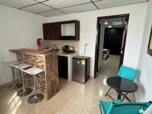 cocina con encimera y sillas en una habitación en Acogedor apartaestudio ubicado en la zona rosa de Pereira en Pereira