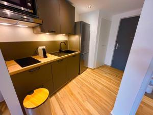 a kitchen with a sink and a wooden floor at orient bay studio -alamanda front de mer in Orient Bay