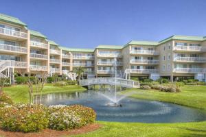 a large apartment building with a pond and a fountain at St. Simons Grand 224 in East End