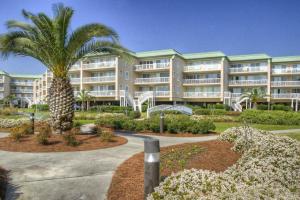 a large building with a palm tree in front of it at St. Simons Grand 224 in East End