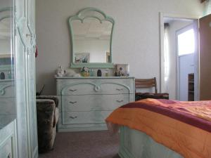 a bedroom with a dresser and a mirror at Bungalow in Altglietzen für 2 Personen und 1 Kind bis 6 Jahren in Altglietzen