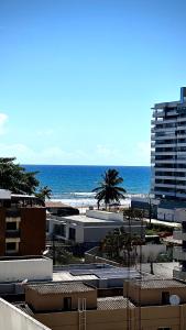 イリェウスにあるApt. em Praia do Sul de Ilhéusの建物と海を望むビーチの景色を望めます。