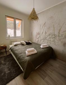 a bedroom with a bed with two towels on it at Chatka Niedźwiadka in Uście Gorlickie