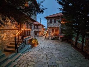 una casa con entrada de piedra frente a un edificio en Nemesis Suites, en Palaios Agios Athanasios