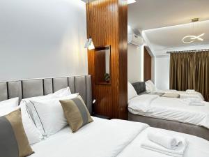 pokój hotelowy z 2 łóżkami z białą pościelą w obiekcie Vila Lordev w mieście Korcza