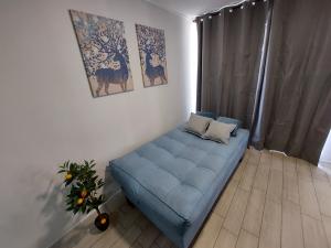 a living room with a blue couch in a room at Apartamento Santiago Caupolicán in Santiago