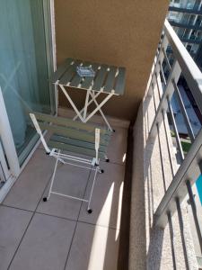 a green chair on a balcony with a table at Apartamento Santiago Caupolicán in Santiago