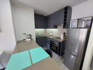 a kitchen with a table and a refrigerator at Apartamento Santiago Caupolicán in Santiago