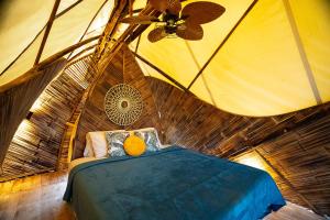 a room with a bed and a ceiling fan at Jungle Gayborhood - LGBTQ Boutique Hotel and Retreat in San Luis