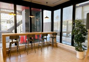 a bar with stools in a room with windows at Smile Hotel Sapporo Susukino Minami in Sapporo