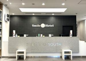 un negozio di fronte a un hotel sorridente con due sgabelli di Smile Hotel Sapporo Susukino Minami a Sapporo
