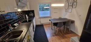 a kitchen with a sink and a table with chairs at Friesenhaus1822 in Tettens in Wangerland