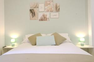 1 dormitorio con 1 cama blanca y 2 lámparas en Cornelia IDI Gemelli, Chicca Metro Apartment, en Roma