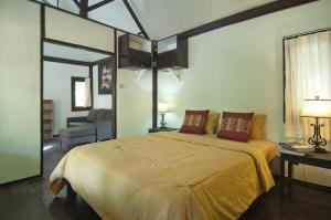 a bedroom with a large bed and a living room at Thank You Bungalow in Gili Meno