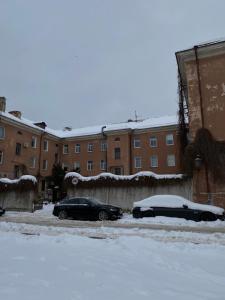 dos autos estacionados en un estacionamiento cubierto de nieve en Studio Apartment Old Town, en Klaipėda