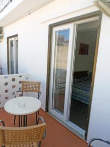 mesa y sillas en una habitación con ventana en Hostal Sol de Mallorca, en El Arenal