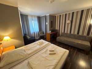 een hotelkamer met een bed en een bank bij WestEnd#106 in Frankfurt am Main
