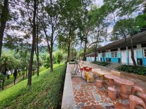 uma fila de bancos de madeira num parque em Puprai Tarnnarm Resort em Thong Pha Phum