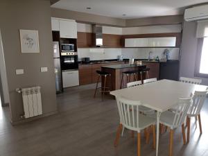 een keuken met een witte tafel en stoelen. bij Los Álamos Vistalba in Ciudad Lujan de Cuyo